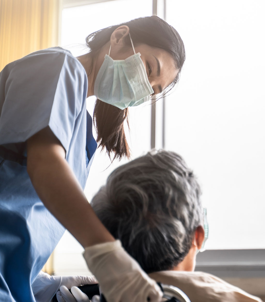 Photo of a masked woman caregiver with a senior woman.