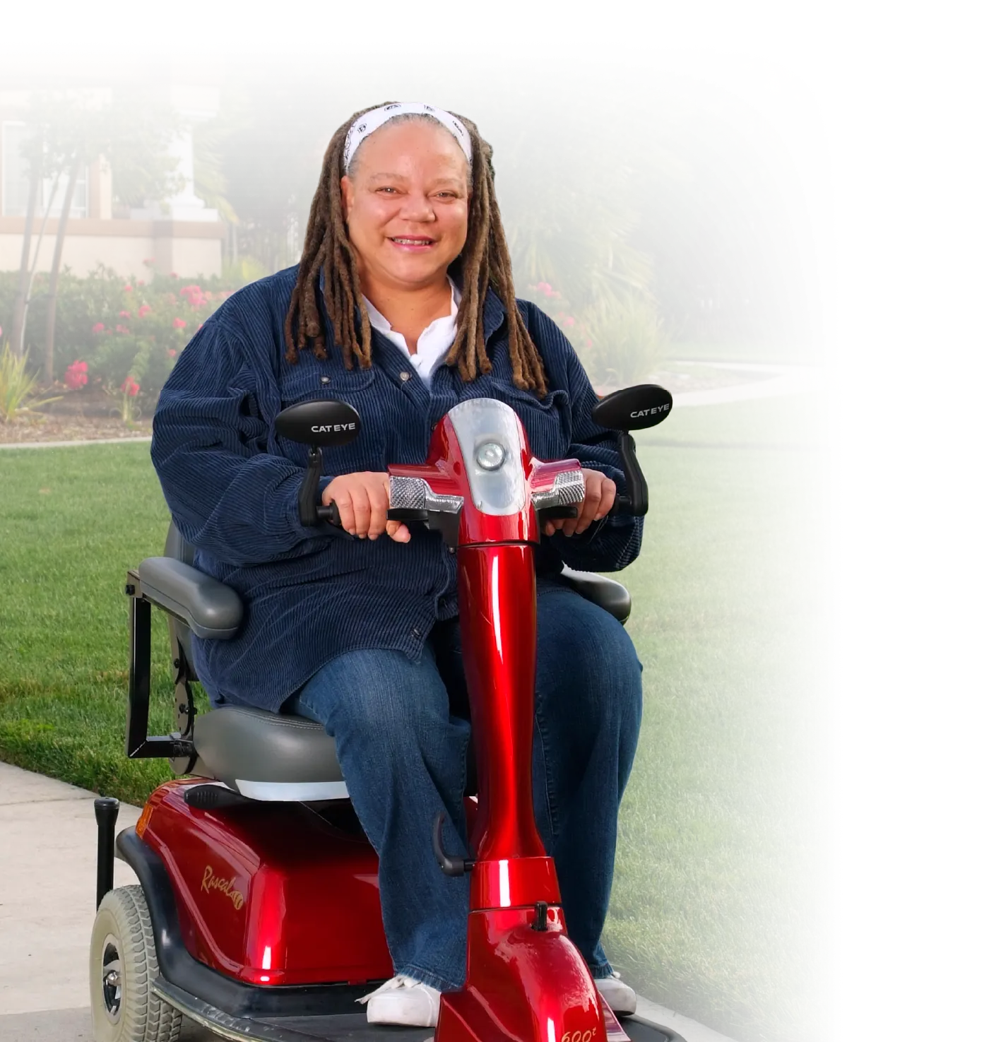 Photo of a middle-aged woman operating a mobility scooter along and walkway.